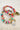 Colorful beaded bracelets with gold accents on a textured surface