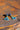 Colorful blue and gold earrings on a rustic wooden surface