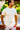 Man wearing a light yellow t-shirt and floral shorts outdoors
