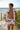 Man in floral beachwear walking by the ocean