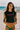 Person wearing a 'Nikki Beach Miami' shirt at the beach with lounge chairs in the background.
