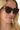 Person wearing large sunglasses with a multi-colored frame