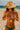 Person on beach wearing a straw hat and a beaded necklace