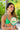 Woman in green bikini holding a beach paddle with 'NIKKI BEACH' text.