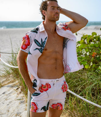 Man in floral beachwear standing by the seaside