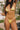 A woman in a yellow bikini holding a glass of wine at poolside.