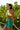 Woman in a bikini and wrap skirt standing among greenery
