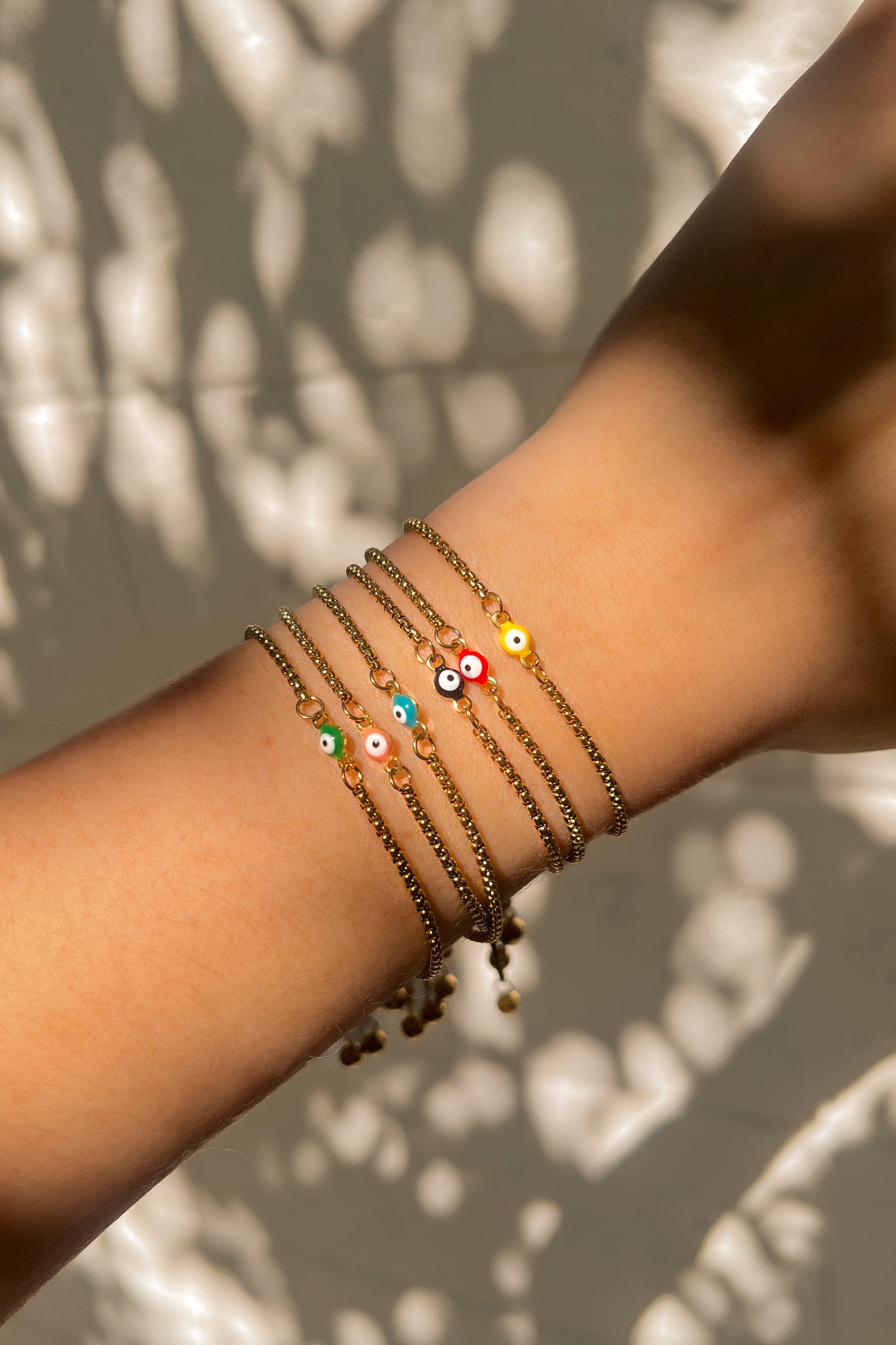 Arm wearing multiple colorful beaded bracelets.