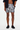 Person wearing black and white patterned shorts on a plain background