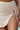 Close-up of a textured beige skirt with a drawstring waist.
